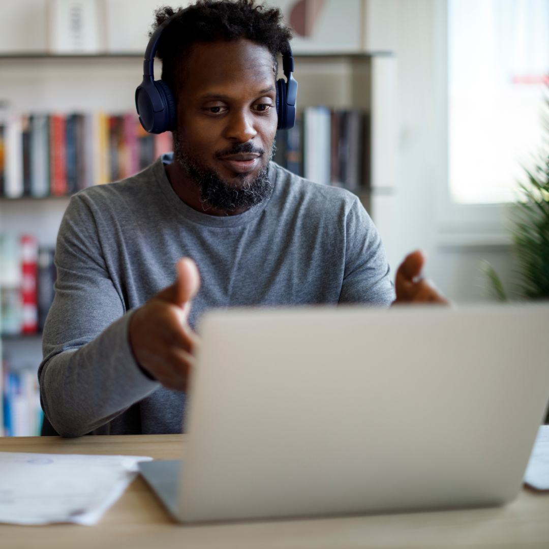 An African-American man sits at a laptop